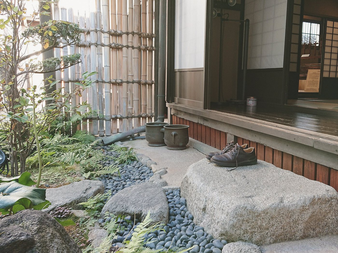 竹垣に囲まれた縁側と、踏み石のある小さな庭